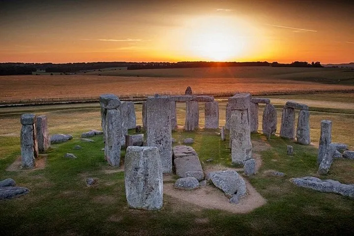 Visitors among the Stonehenge stones at dawn on an inner circle day tour from London, England