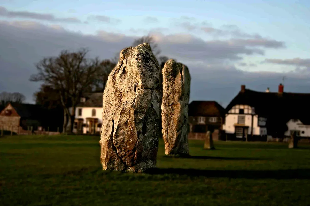 Standing stones at Avebury beside the village houses on a Bath, Avebury and Lacock day trip from London