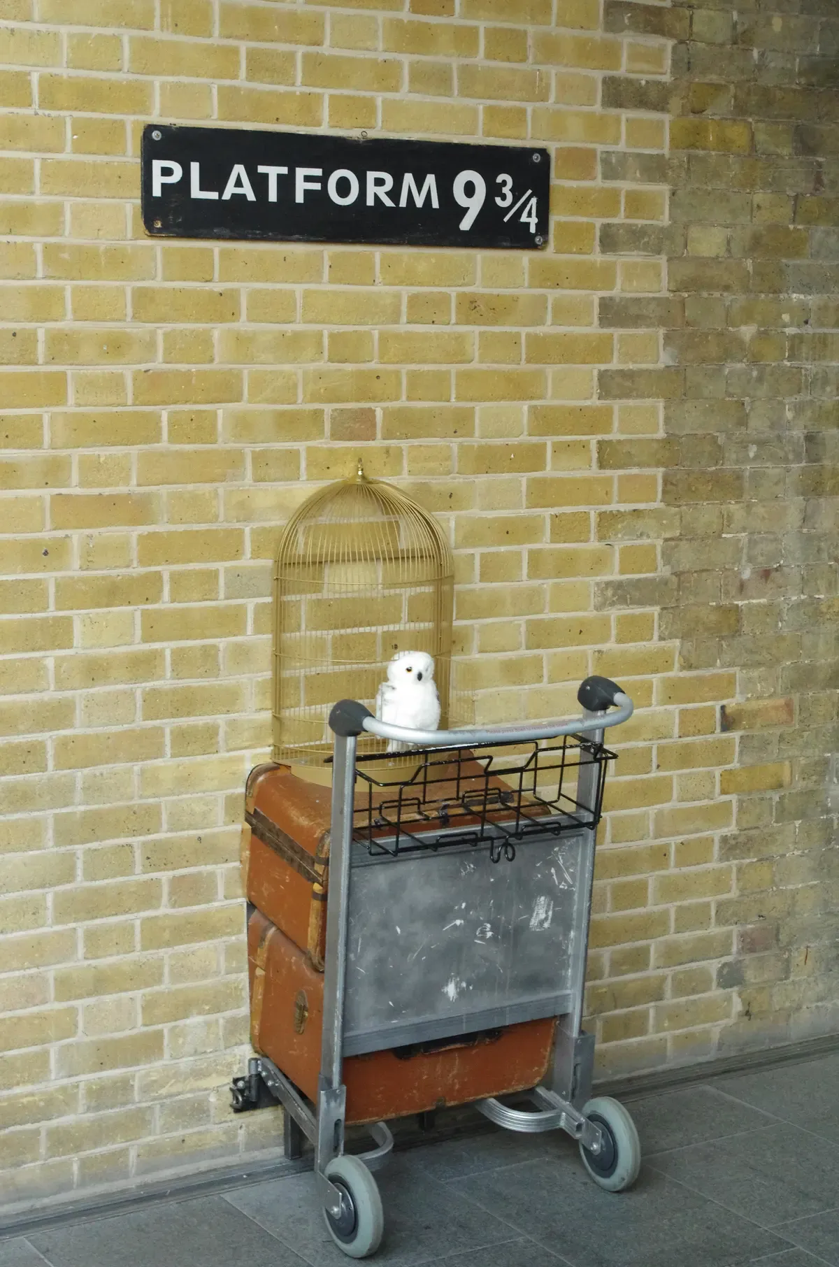 Platform 9 3/4 sign and luggage trolley at King's Cross station on a Harry Potter day trip from London