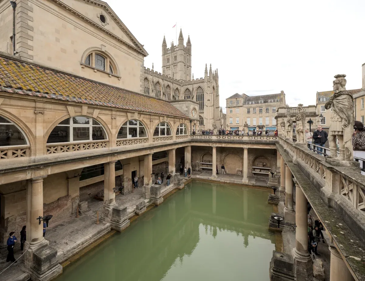 Great Bath at the Roman Baths in Bath with the abbey behind, on a Stonehenge, Windsor and Bath day trip from London